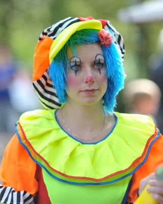 Vrouw geschminkt en verkleed als clown